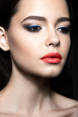 Beautiful woman with evening make-up and pink lips. Beauty face. Picture taken in the studio on a black background.