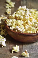 A bowl of popcorn on a wooden table.