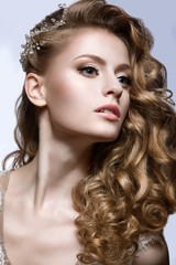 Portrait of a beautiful woman in the image of the bride with barrette in her hair. Picture taken in the studio on a grey background