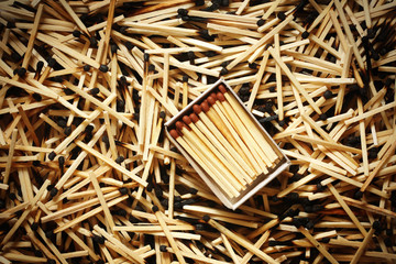 Matchbox with matches on a background of burnt matches