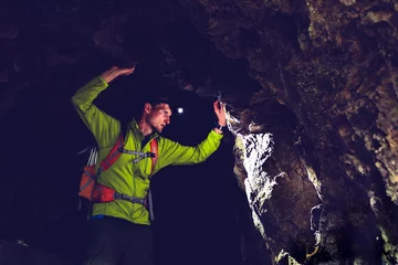 Fototapeten Man exploring underground dark cave tunnel © blas
