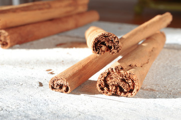 Some cinnamon sticks on a white wooden table. Macro