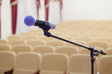 The image of microphone and blurred auditorium in the background