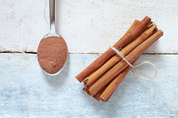 Cinnamon sticks tied next, a spoon with some powdered cinnamon.