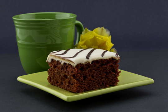 Focus On Red Velvet Cake On Green Plate With Mug And Flower