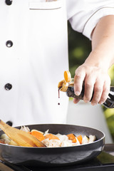Chef pouring shoyu sauce to the pan for cooking Japanese pork cu
