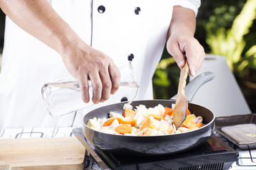 Chef pouring soup to the pan for cooking Japanese pork curry