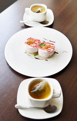 Two cups of tea and cakes on a large plate