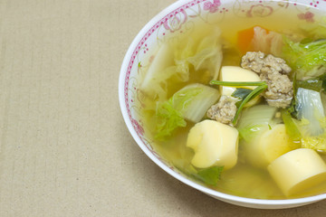 clear soup with bean curd and minced pork in dish on cardboard b