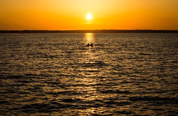 paddle boarders in the sunset