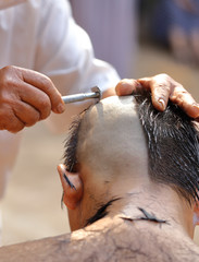 Naklejka premium Male who will be monk shaving hair for be Ordained
