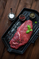 Cast-iron grill with fresh beef barbecue steak, above view