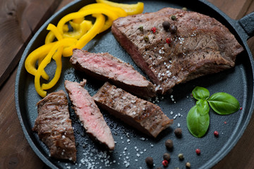 Medium grilled beef barbecue steak on a frying pan, close-up