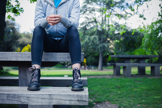 Woman wearing boots sitting on bench