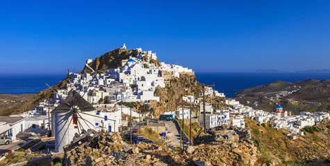Authentic Cycladic style village of Chora overlooking the Aegean sea. Panoramic view of Serifos island with historic windmills and white houses.