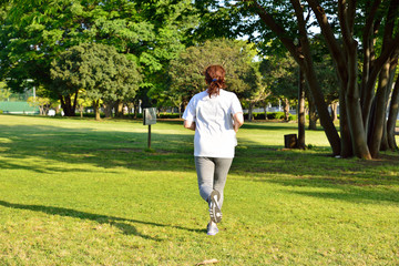 公園でジョギングするミドルエイジの日本人女性