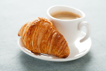 Cup of coffee and croissant
