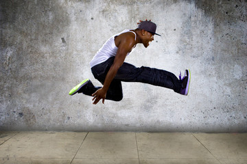 hip hop dancer jumping high on concrete 