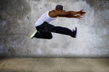 hip hop dancer jumping high on concrete 
