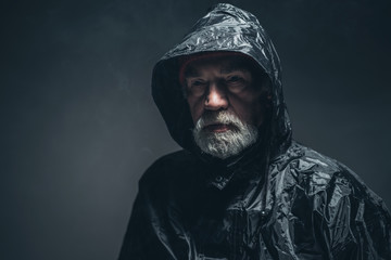 Thoughtful Bearded Senior Man Wearing Raincoat