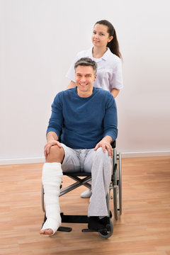 Doctor With Disabled Patient On Wheelchair