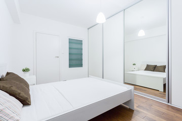 Fototapeta na wymiar White bedroom in contemporary apartment