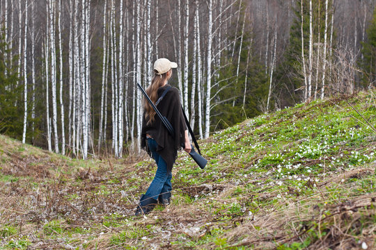 Woman hunter shooting on the forest edge