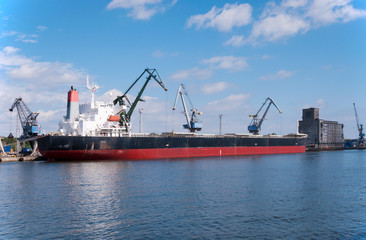 Port cranes loading a ship in the harbor in Gdansk