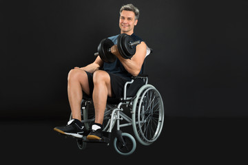 Fototapeta na wymiar Handicapped Man On Wheelchair Working Out With Dumbbell