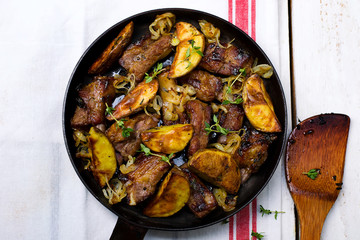 ribs fried with potato on a frying pan
