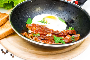 bacon and eggs in a frying pan