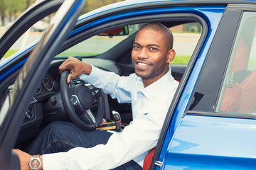 Happy handsome man in his new blue car