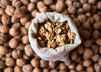 Walnuts kernels in the sack on the pile of walnuts