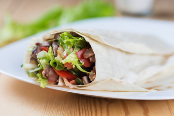 Tortilla with a delicious grilled meat and fresh mixed leafy gre