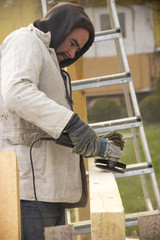 a man with a beard, a builder, working with wood, wood grinder g