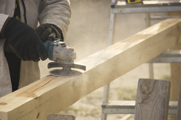 a man with a beard, a builder, working with wood, wood grinder g