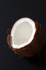 Half a coconut displayed on a dark background