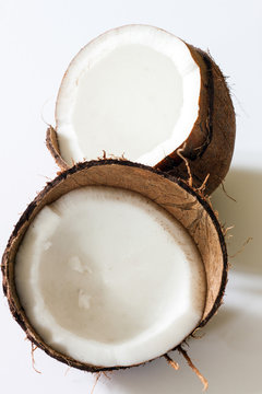 A coconut displayed in two halves on a white background