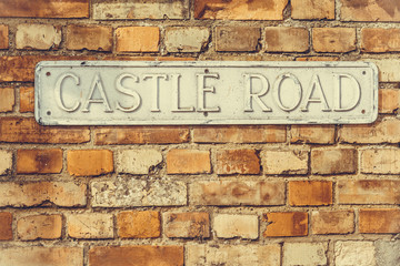 'Castle Road' sign on a weathered wall vintage look weathered wa