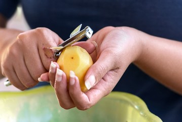 Potato is peeled with a kitchen knife