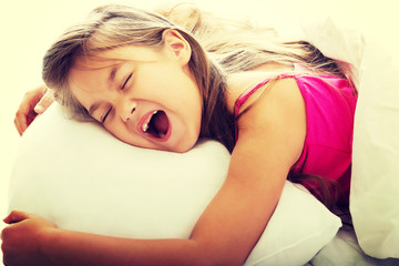 Young girl yawning while waking up