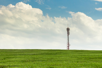 Obraz premium antenna on the grassy knoll and blue sky.