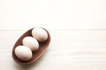 Tre uova in ciotola di ulivo