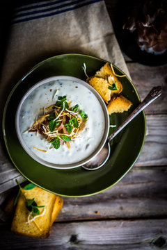 Cream soup with bread and meat on wooden background
