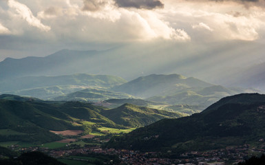 Raggi di sole al tramonto tra le colline e montagne marchigiane