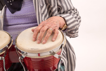 Funny elderly lady playing bongo.