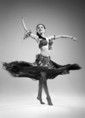 Beautiful young woman in a dress dancing in the studio