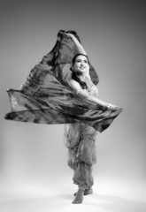 Beautiful young woman in a dress dancing in the studio