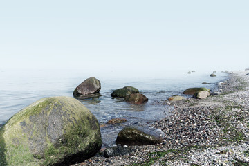 large stones on the sea beach, background foggy