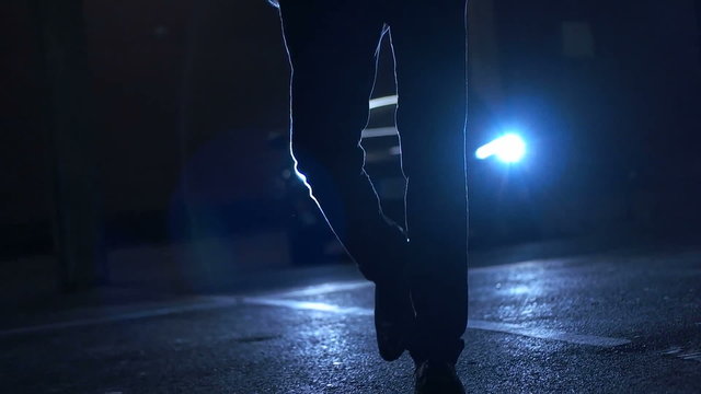 man walking in the suit with car lights